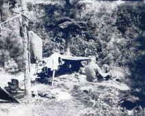 Canoe17 Gene Swarthout putting on boots at his "bedroom" in the woods.