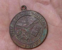 Wellsville2 "A gardener found this medal while working the soil and asked us to identify it. Can anyone help? It says "Village of Wellsville 1857" Three sections are...